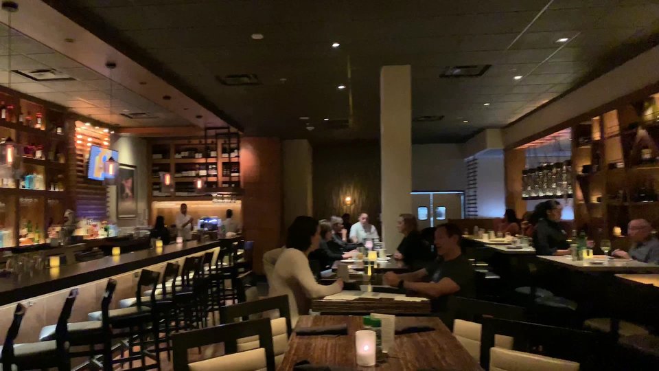 Warm dining room with tables and bar seating.